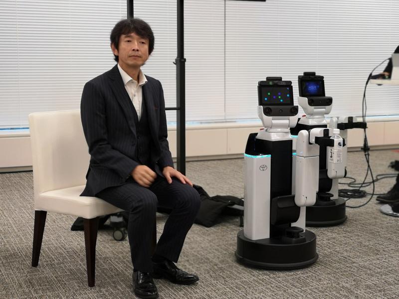 Toyota Motor Corp Frontier Research Centre chief officer Nobby Koga with two Human Support Robots (HSR).