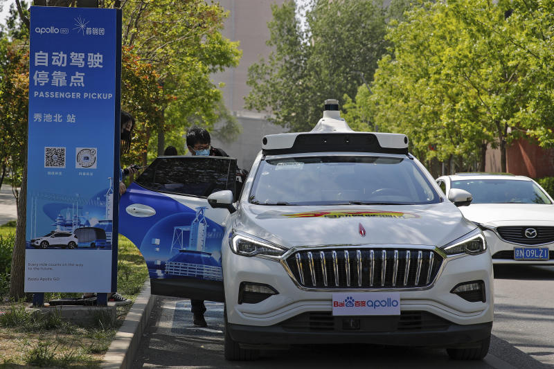 A man getting into a Baidu Apollo Robotaxi at a passenger pickup point setup at the Shougang Park in Beijing on Sunday. — AP 