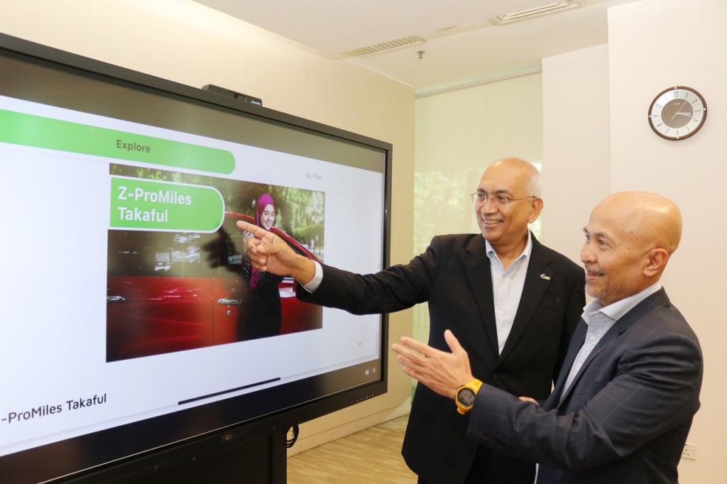 Azman (left) and Shamsul showing the benefits of the coverage plan.