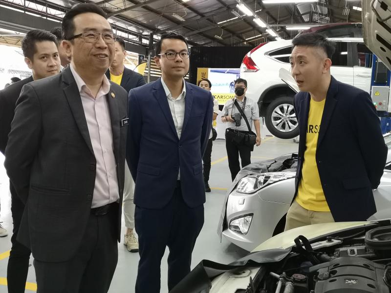 Cheng (left) showing the centre's operations to Chang (on left) and Lee (centre).