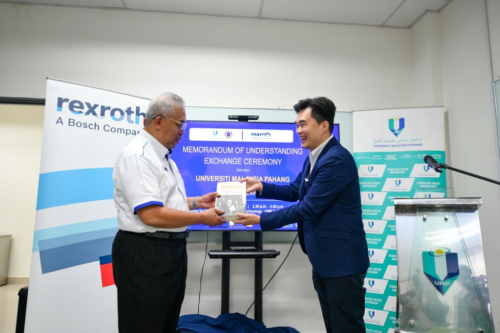 Dr Yuserie (left) exchanging MoU documents with Chan.