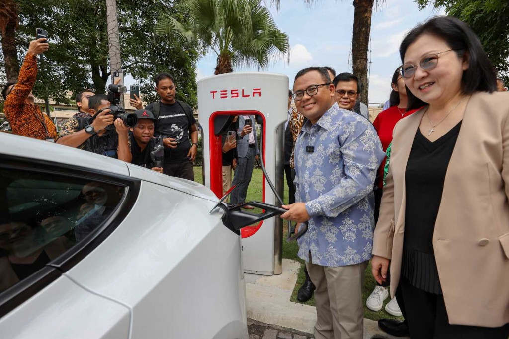 Selangor Mentri Besar Datuk Seri Amirudin Shari plugging the supercharger gun into a Tesla vehicle at the launch of the Tesla Supercharger station in Sunway Pyramid. With him is Tesla regional director Isabel Fan.