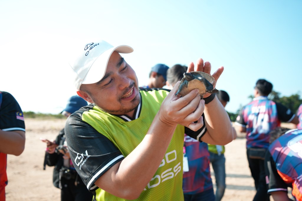 Photo 3 - Chery staff member taking a closer look at a terrapin during a visit to the conservation centre in Kemaman, Terengganu. (Custom)